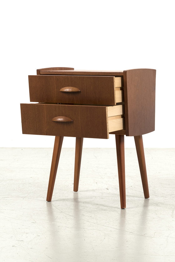 Image 1 of Kleine Kommode aus Teakholz steht im Schaufenster der TUINSTRAAT